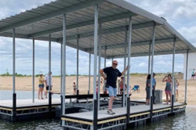 Man Standing on a floating dock with a canopy over it
