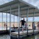 Man Standing on a floating dock with a canopy over it